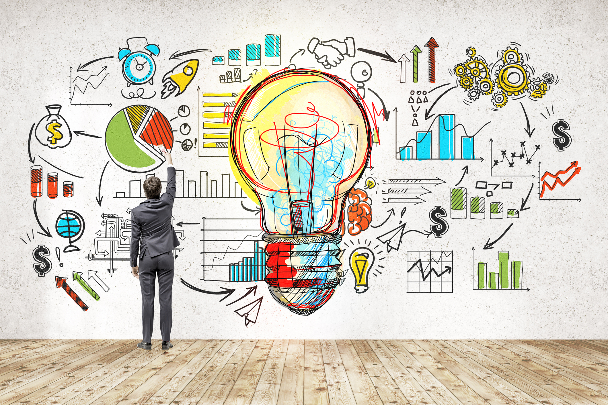 Rear view of businessman in suit drawing colorful startup sketch. Large light bulb icon in center. Concept of successful startupper