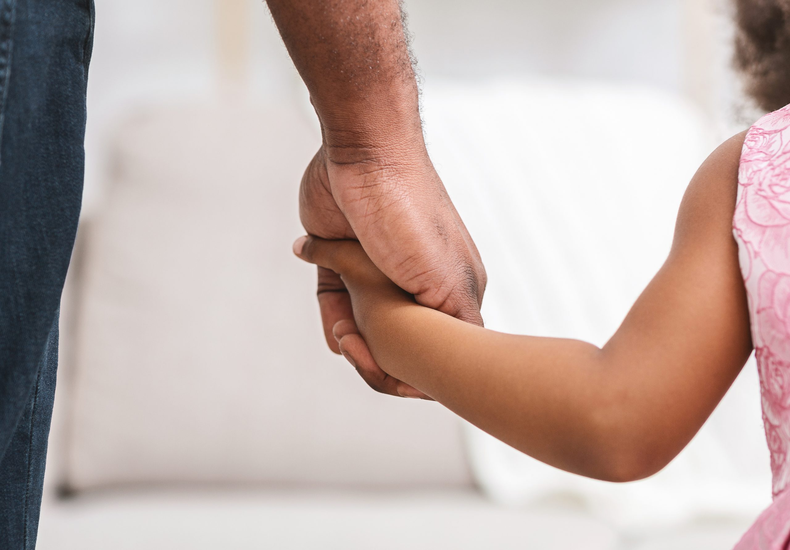 Black father giving hand to his little daughter, close up, supporting, care, parenthood concept