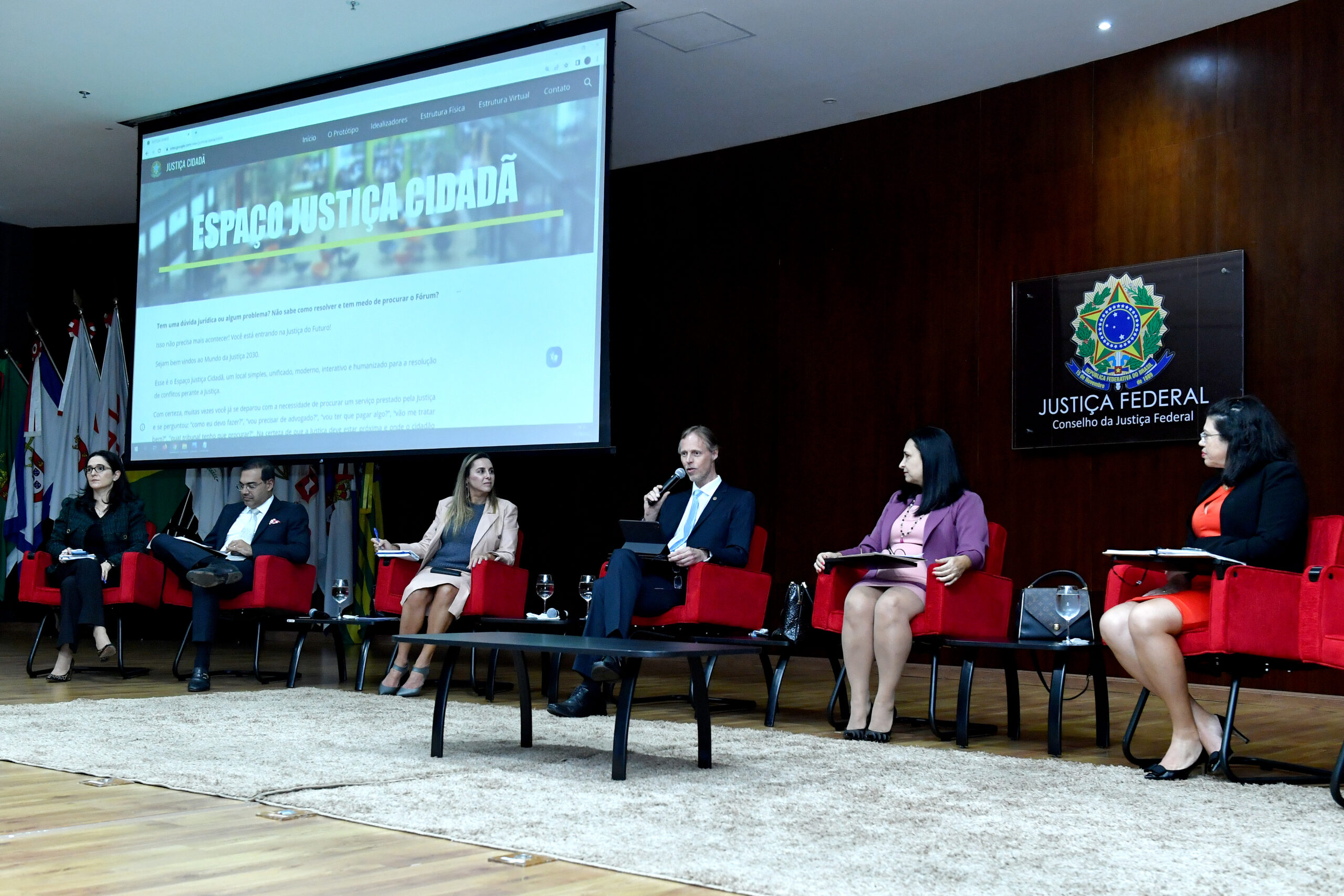 Palestrantes do evento de encerramento da especialização apresentando um slide sobre o espaço justiça cidadã